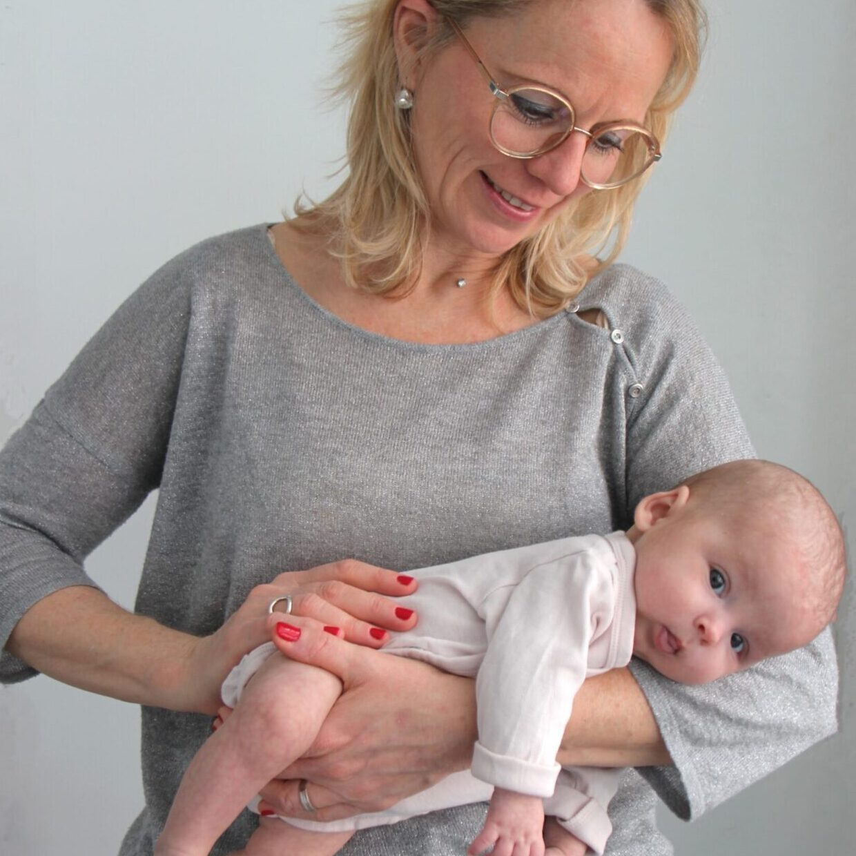 Atelier guidance Cette image représente Florence Le ber Maury tenant sur son avant bras un bébé à plat ventre